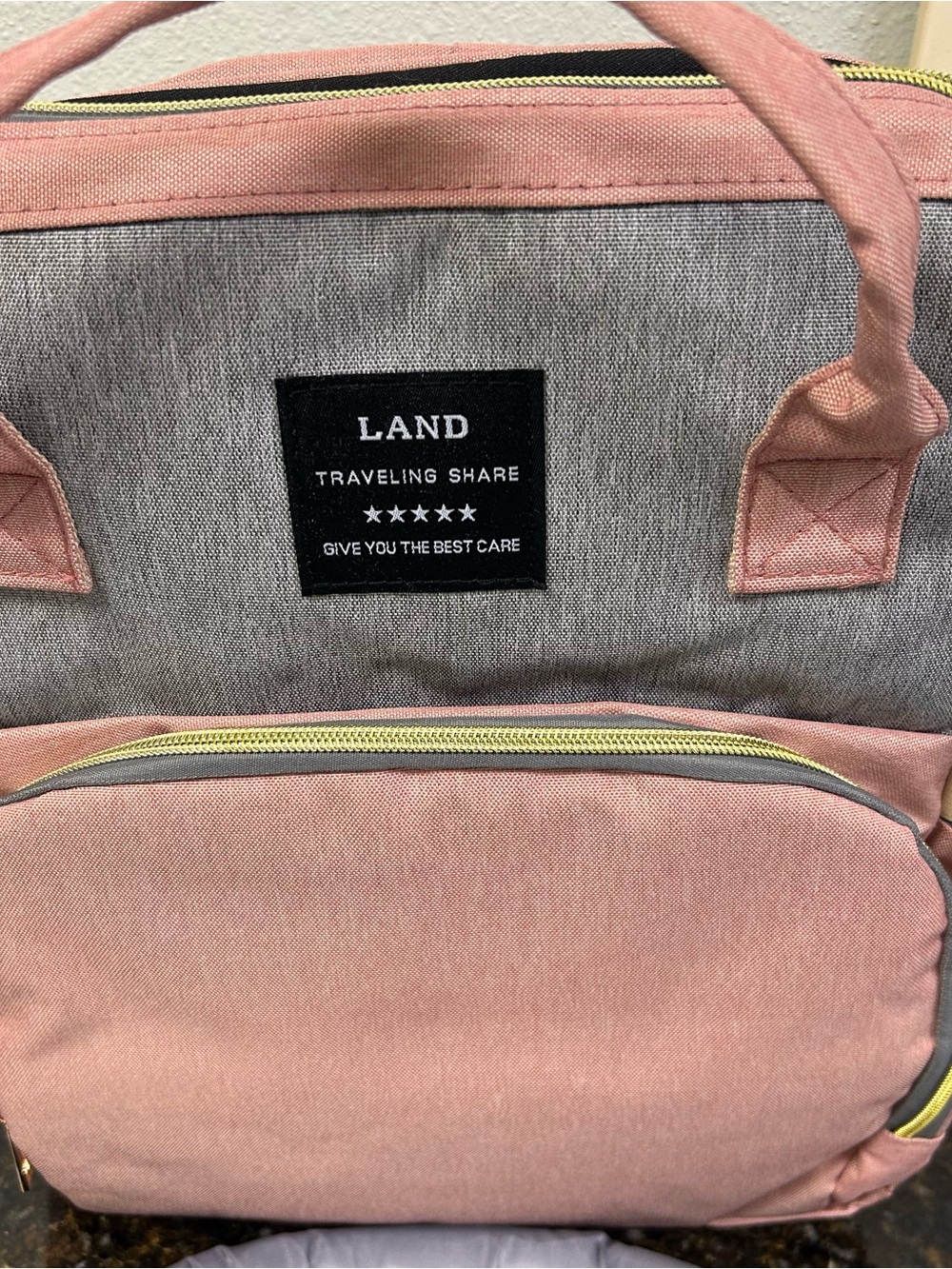 LAND Traveling Share diaper bag backpack in a pink and gray color scheme